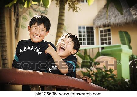 Hispanic boys laughing in courtyard View Large Photo Image Stock Photograph - Hispanic boys laughing in courtyard. Fotosearch