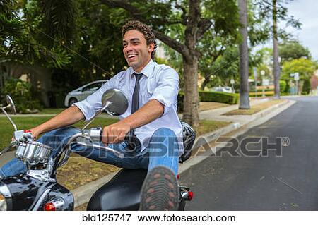 Hispanic businessman driving moped on neighborhood road View Large Photo Image Stock Photo - Hispanic businessman driving moped on neighborhood road. Fotosearch