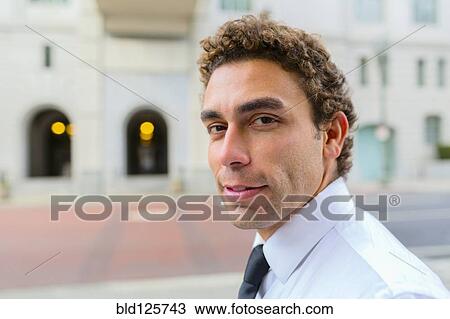 Stock Image - Hispanic businessman on city street. Fotosearch
