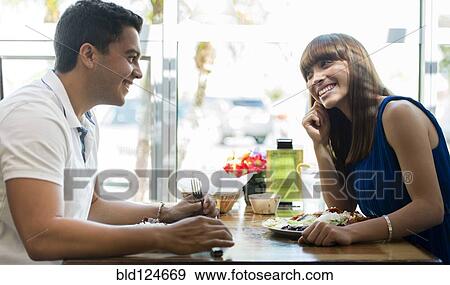 Stock Photo - Hispanic couple eating together at cafe. Fotosearch