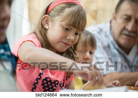 Picture - Hispanic family eating dinner at table. Fotosearch