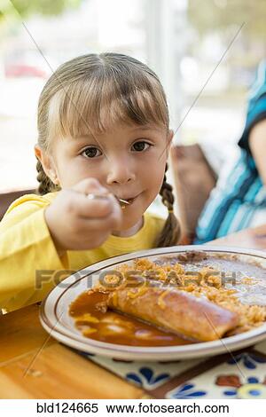 Hispanic girl eating dinner at table View Large Photo Image Stock Photography - Hispanic girl eating dinner at table. Fotosearch
