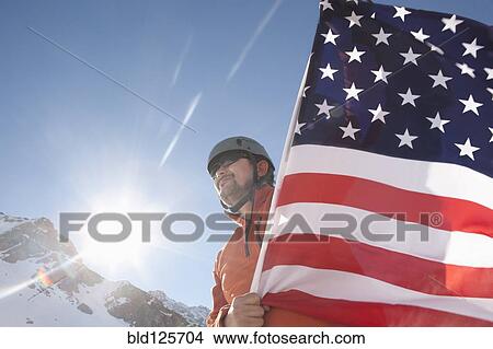 Hispanic hiker planting American flag on snowy mountain View Large Photo Image Picture - Hispanic hiker planting American flag on snowy mountain. Fotosearch