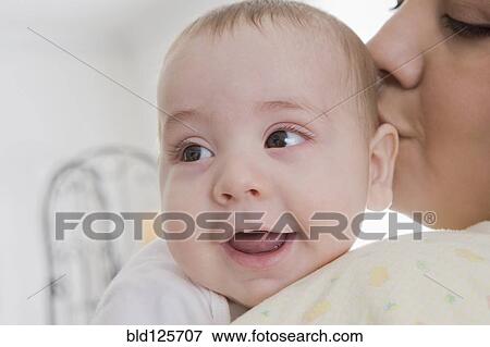 Hispanic mother kissing baby boy View Large Photo Image Stock Photo - Hispanic mother kissing baby boy. Fotosearch