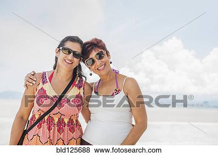 Hispanic women smiling together on beach View Large Photo Image Stock Photo - Hispanic women smiling together on beach. Fotosearch