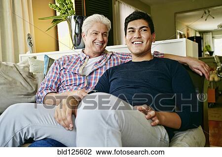 Homosexual couple relaxing on sofa View Large Photo Image Stock Image - Homosexual couple relaxing on sofa. Fotosearch