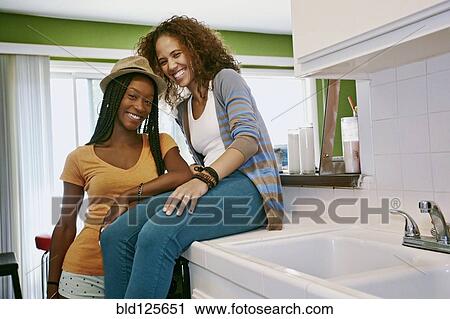 Stock Image - Homosexual couple smiling together in kitchen. Fotosearch