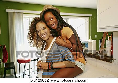 Homosexual couple smiling together in kitchen View Large Photo Image Stock Image - Homosexual couple smiling together in kitchen. Fotosearch