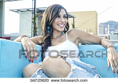 Middle Eastern woman relaxing on sofa on urban balcony View Large Photo Image Stock Image - Middle Eastern woman relaxing on sofa on urban balcony. Fotosearch
