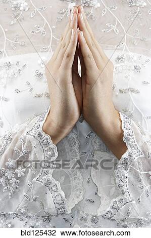 Stock Image - Mixed race bride's hands in prayer position. Fotosearch