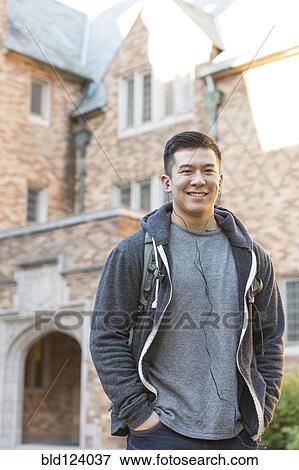 Stock Photo - Mixed race college student listening to music on headphones. Fotosearch
