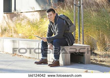 Stock Image - Mixed race college student using digital tablet on campus. Fotosearch