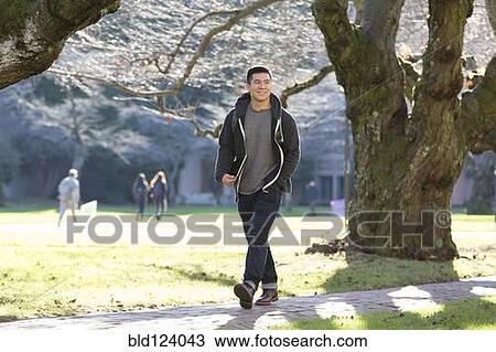 Mixed race college student walking on campus View Large Photo Image Stock Image - Mixed race college student walking on campus. Fotosearch