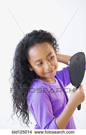 Mixed race girl admiring herself in mirror View Large Photo Image Picture - Mixed race girl admiring herself in mirror. Fotosearch