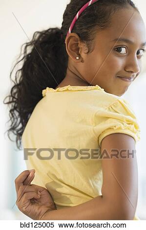 Mixed race girl crossing fingers behind her back View Large Photo Image Stock Photography - Mixed race girl crossing fingers behind her back. Fotosearch