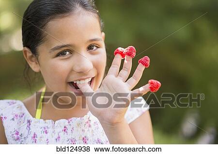 Mixed race girl eating raspberries on fingers outdoors View Large Photo Image Stock Photo - Mixed race girl eating raspberries on fingers outdoors. Fotosearch