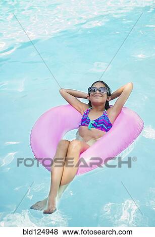 Mixed race girl floating in swimming pool View Large Photo Image Stock Photo - Mixed race girl floating in swimming pool. Fotosearch