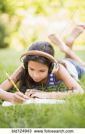 Mixed race girl listening to headphones and drawing outdoors View Large Photo Image Stock Image - Mixed race girl listening to headphones and drawing outdoors. Fotosearch