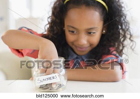 Mixed race girl putting coins in summer savings jar View Large Photo Image Stock Image - Mixed race girl putting coins in summer savings jar. Fotosearch