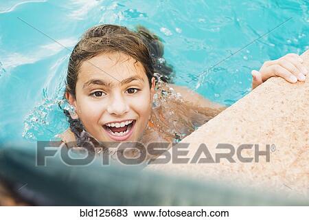 Stock Image - Mixed race girl swimming in pool. Fotosearch