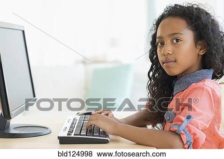 Mixed race girl using computer at desk View Large Photo Image Stock Photo - Mixed race girl using computer at desk. Fotosearch