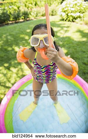 Picture - Mixed race girl wearing snorkeling gear in wading pool. Fotosearch