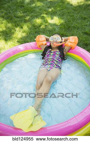 Stock Photography - Mixed race girl wearing snorkeling gear in wading pool. Fotosearch