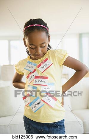 Stock Photograph - Mixed race girl wearing various name tags. Fotosearch