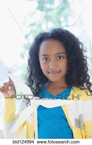 Picture - Mixed race girl with model wind turbine. Fotosearch