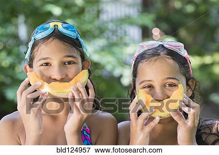 Mixed race girls playing with cantaloupes outdoors View Large Photo Image Stock Photo - Mixed race girls playing with cantaloupes outdoors. Fotosearch