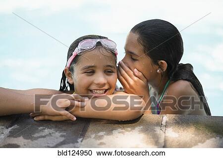 Mixed race girls whispering in swimming pool View Large Photo Image Stock Image - Mixed race girls whispering in swimming pool. Fotosearch