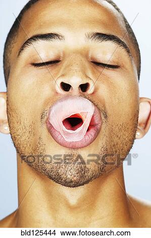 Mixed race man popping bubble gum View Large Photo Image Picture - Mixed race man popping bubble gum. Fotosearch