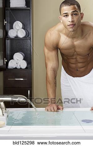Mixed race man running bath View Large Photo Image Stock Photo - Mixed race man running bath. Fotosearch