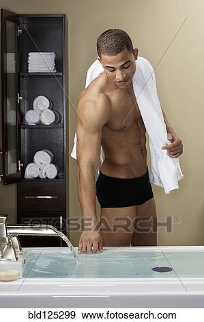 Mixed race man running bath View Large Photo Image Stock Photo - Mixed race man running bath. Fotosearch