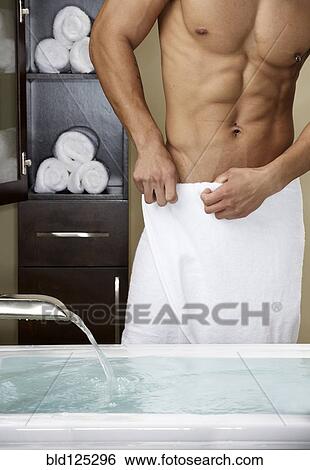 Stock Photograph - Mixed race man running bath. Fotosearch