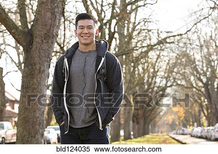 Mixed race man walking on suburban street View Large Photo Image Stock Photography - Mixed race man walking on suburban street. Fotosearch
