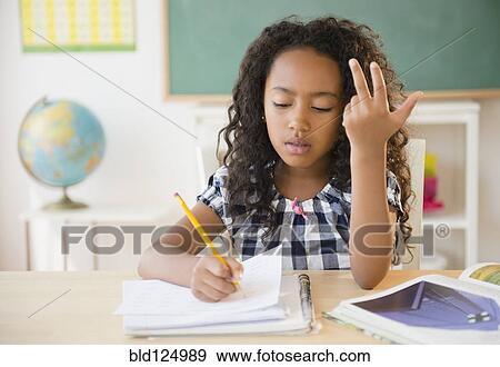 Mixed race student counting on fingers in classroom View Large Photo Image Stock Photo - Mixed race student counting on fingers in classroom. Fotosearch