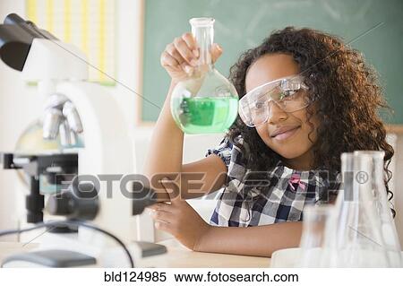 Stock Photography - Mixed race student working in chemistry lab. Fotosearch