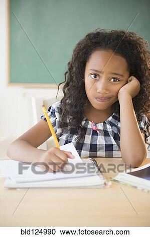 Stock Image - Mixed race student working in classroom. Fotosearch