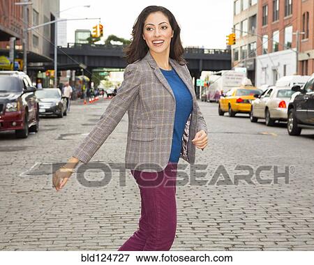 Stock Photo - Mixed race woman crossing city street. Fotosearch