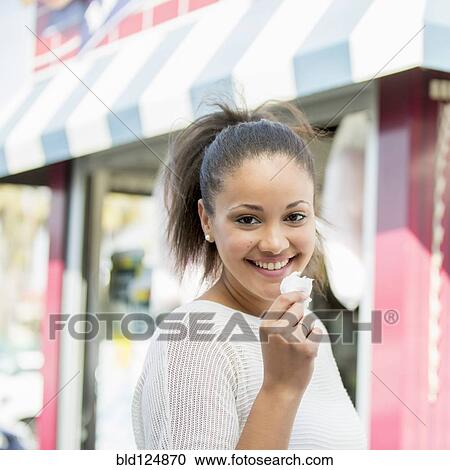 Mixed race woman eating cotton candy View Large Photo Image Stock Image - Mixed race woman eating cotton candy. Fotosearch
