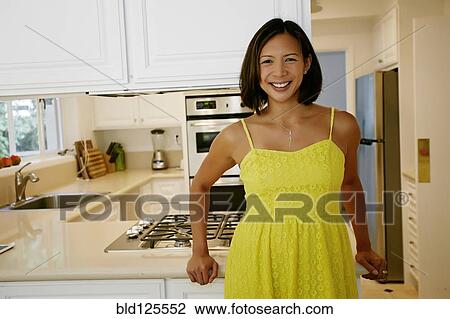 Mixed race woman smiling in kitchen View Large Photo Image Stock Image - Mixed race woman smiling in kitchen. Fotosearch