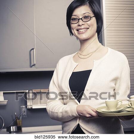 Mixed race woman smiling in kitchen View Large Photo Image Stock Photography - Mixed race woman smiling in kitchen. Fotosearch
