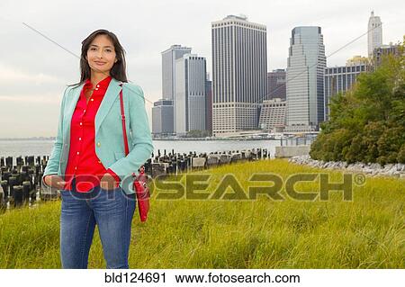 Stock Image - Mixed race woman smiling in park, New York, New York, United States. Fotosearch
