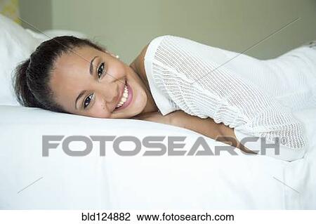 Mixed race woman smiling on bed View Large Photo Image Stock Image - Mixed race woman smiling on bed. Fotosearch