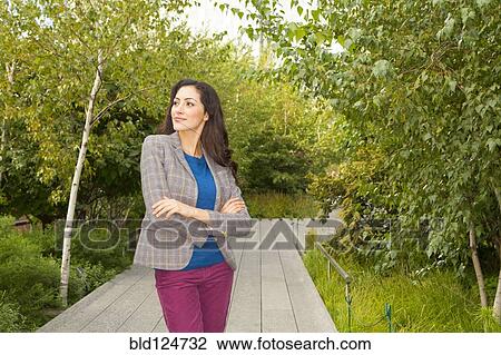 Stock Image - Mixed race woman standing in park. Fotosearch