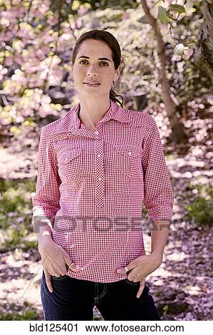 Stock Image - Mixed race woman standing in park. Fotosearch
