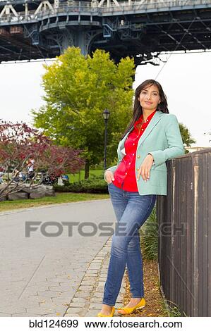 Stock Photo - Mixed race woman standing on urban sidewalk. Fotosearch