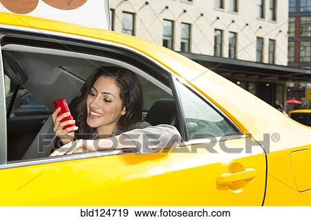 Mixed race woman using cell phone in taxi View Large Photo Image Stock Photo - Mixed race woman using cell phone in taxi. Fotosearch