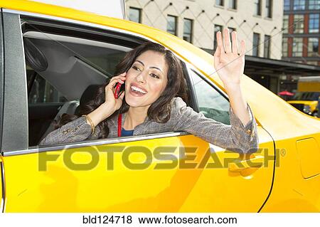 Stock Photo - Mixed race woman waving from taxi. Fotosearch